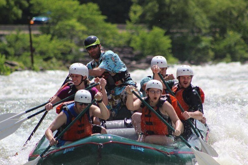 A group of people in a raft navigating a river. 2