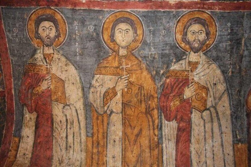 A religious icon with three figures, each with a halo and holding a book. 2