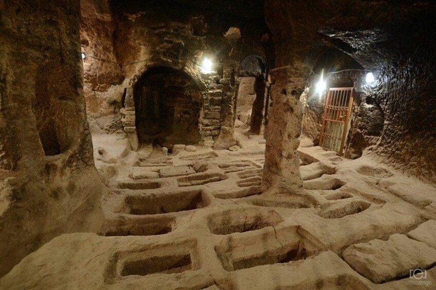 An ancient cave with stone structures and a wooden gate. 5