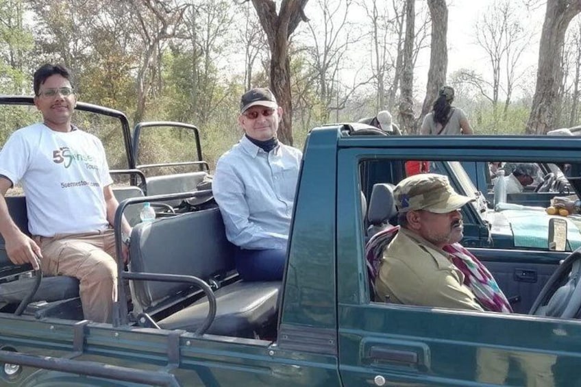 A group of people in a vehicle with a forested background. 2