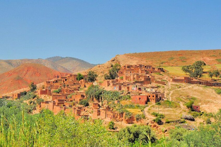 A village with terraced adobe buildings, surrounded by hills and sparse vegetation. 3
