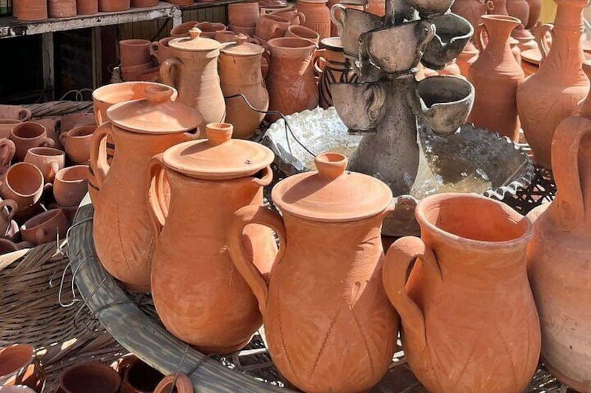 En samling terracotta keramiske genstande, herunder krukker, kande og et dekorativt stativ. 3