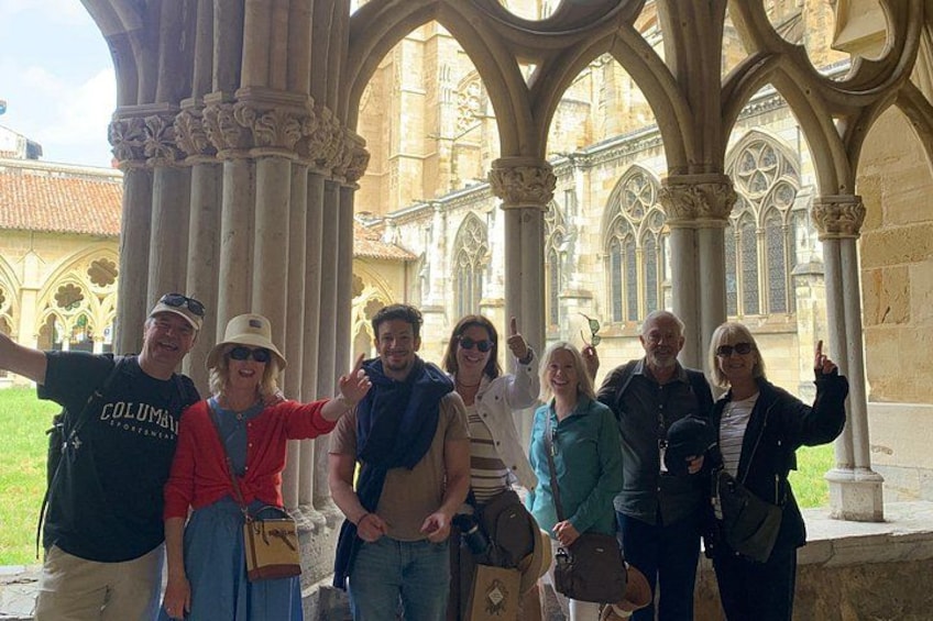 A group of people standing in a historical building with Gothic architecture, including pointed arches and ribbed vaults. 1