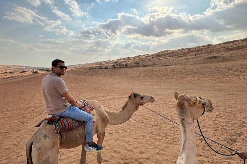 A person riding a camel in a desert landscape. 5