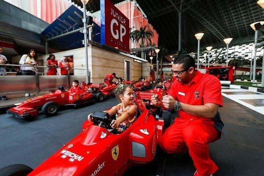 Children in red race cars at a racing event. 5