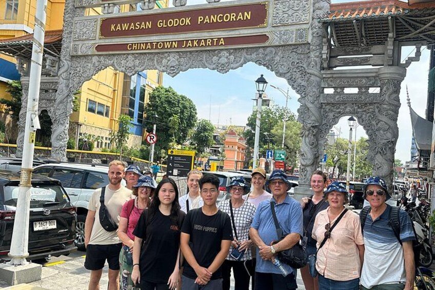 A group of people standing in front of a sign that reads 'Kawasan Glodok Pancoran' and 'Chinatown Jakarta'. 5