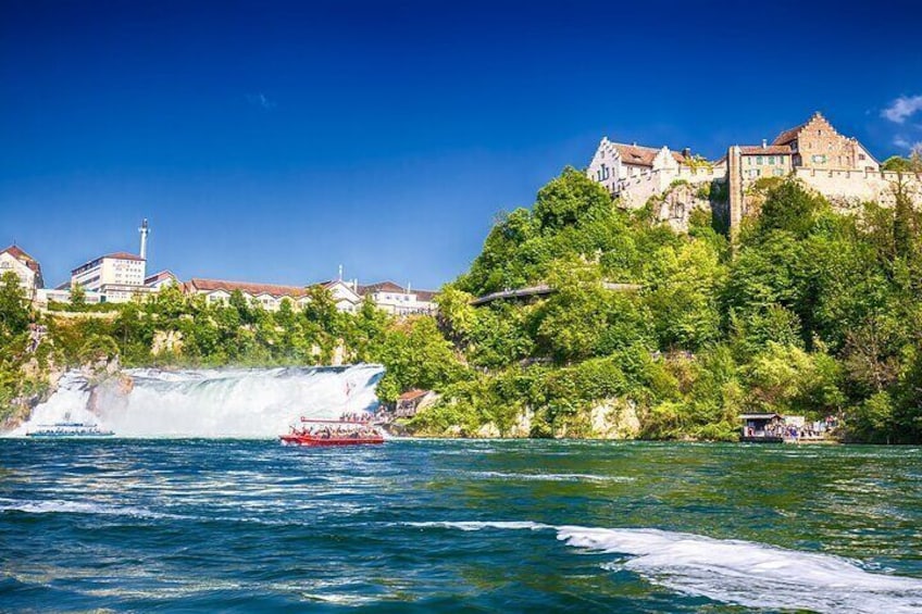 Una cascata, una barca rossa e un castello su una collina. 1