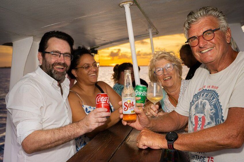 A group of people on a boat, holding drinks and toasting. 5