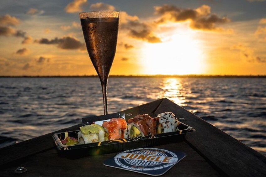 A meal on a boat with a sunset in the background. 1