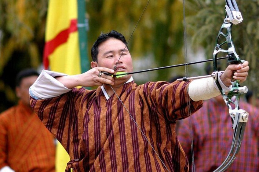 A person in a striped shirt aiming a bow and arrow. 3