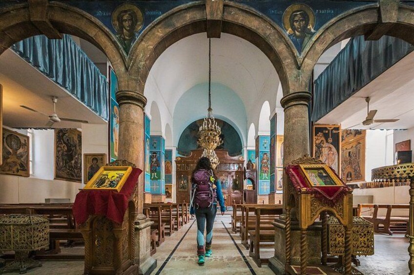 A person walking through a church with arched ceilings and religious icons. 2