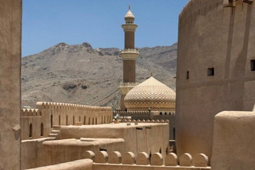 Paisaje desértico con una mezquita que presenta un minarete y una cúpula. 2
