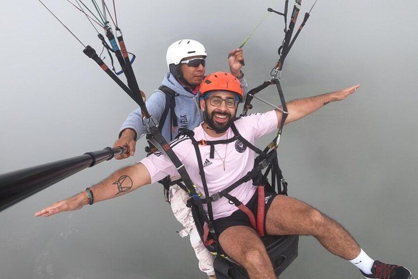 A person paragliding with a harness and parachute. 3