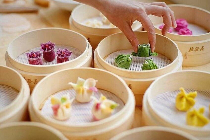 Variedad de dumplings en vaporeras de bambú, algunos con diseños decorativos. 3