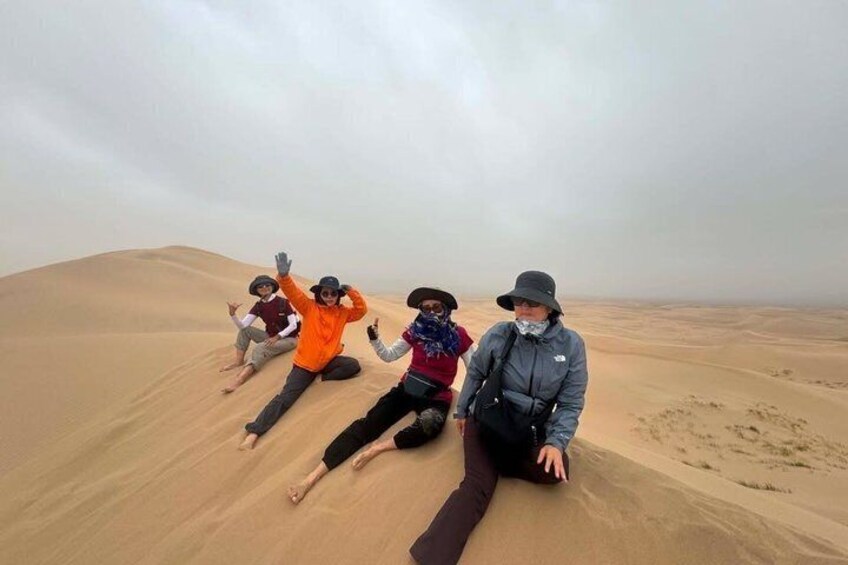 People sliding down a sand dune in a desert. 3