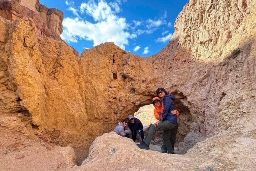 A group of people exploring a rocky canyon with a clear blue sky. 4
