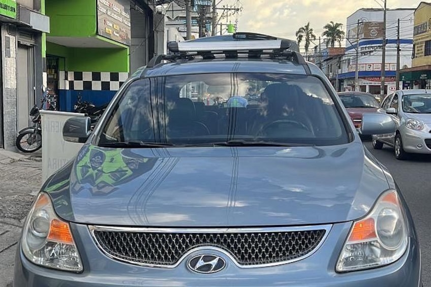 Une voiture Hyundai bleue est garée dans une rue, avec des bâtiments et d’autres véhicules en arrière-plan. 3