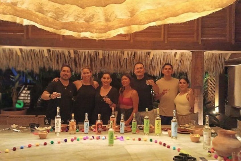 A group of people standing around a table with bottles and a decorative arrangement of colorful balls. 1