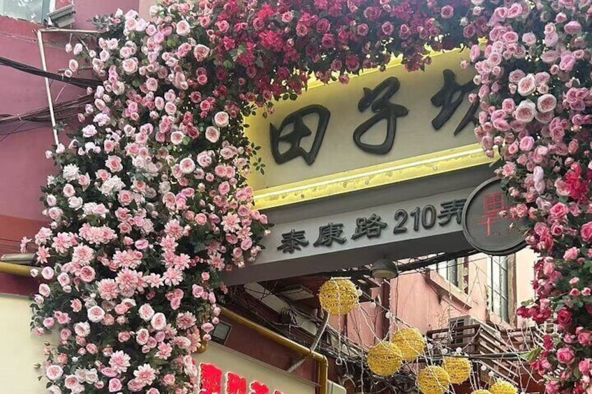 Un escaparate con un letrero en caracteres chinos, rodeado de arreglos florales. 3
