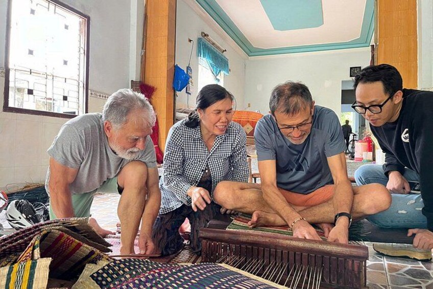 Four people sitting on the floor around a musical instrument. 4
