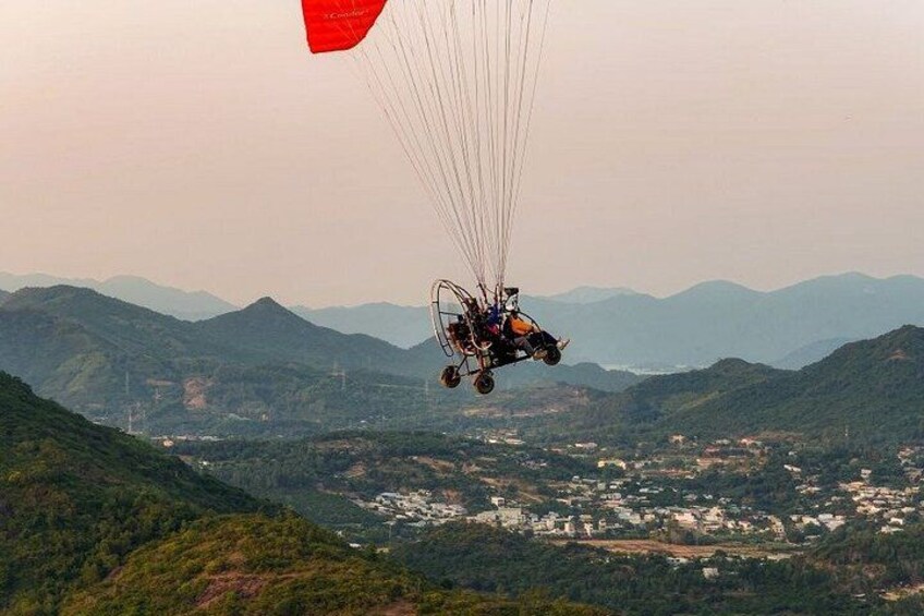 A person paragliding over a mountainous landscape with a red parachute. 2