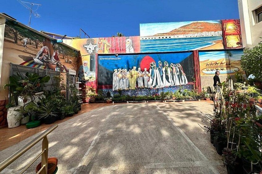 Un mural con un grupo de personas, un círculo rojo grande y una dirección web. 5