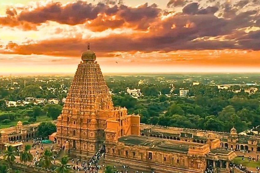 A large temple complex with a prominent tower, surrounded by lush greenery and a vast landscape. 1