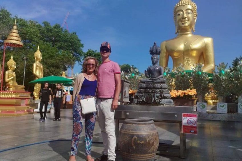 Una gran estatua dorada de Buda, una estatua más pequeña de Buda sentado, y un paraguas tailandés tradicional. 2