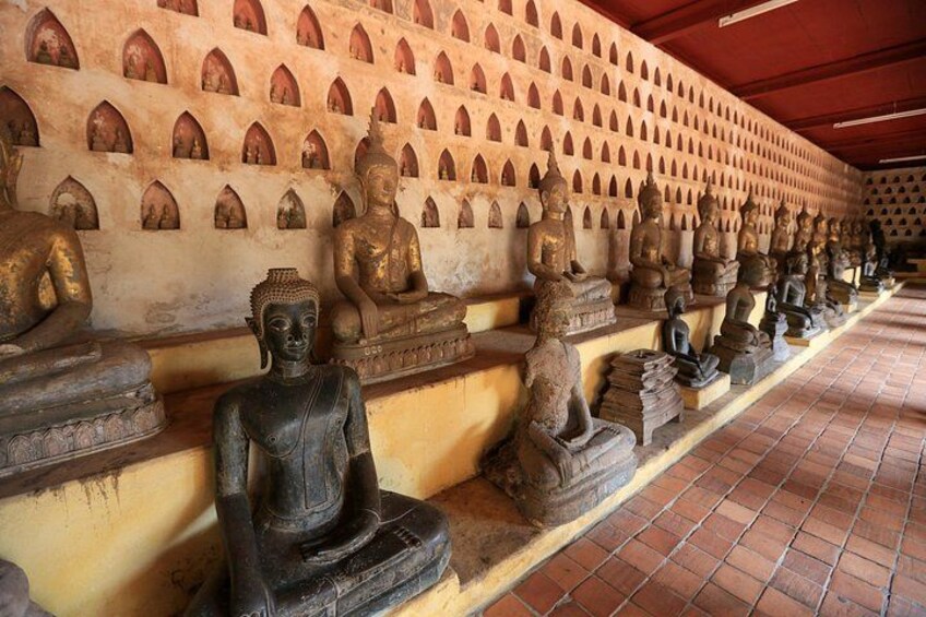A row of seated Buddha statues in a temple. 4
