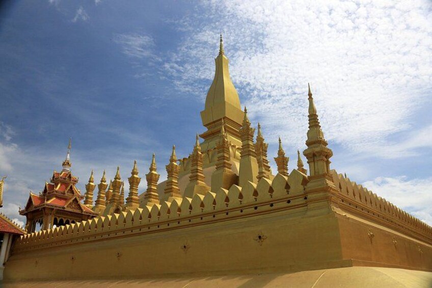 A golden temple with multiple spires and a red-roofed structure to the left. 1