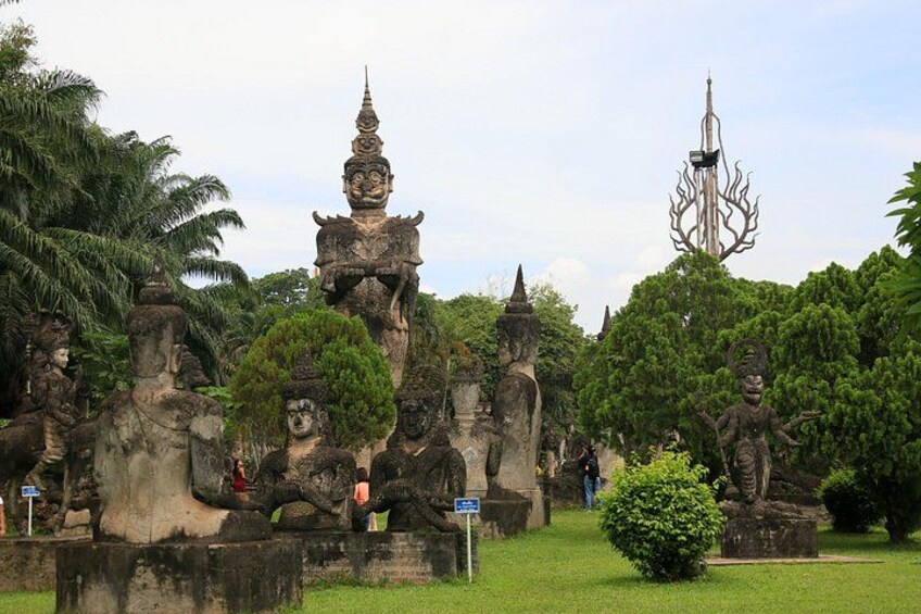 A temple complex with stone statues and a tall spire. 3
