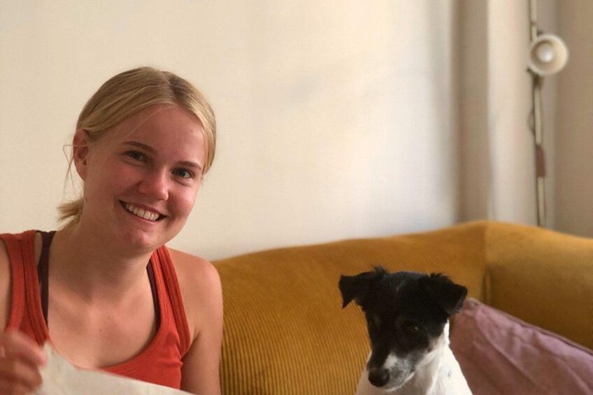 En person sidder på en sofa med en hund. 5