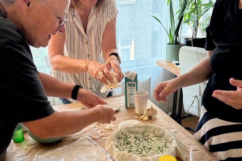Mensen bereiden eten, met ingrediënten zoals kaas en knoflook op tafel. 3