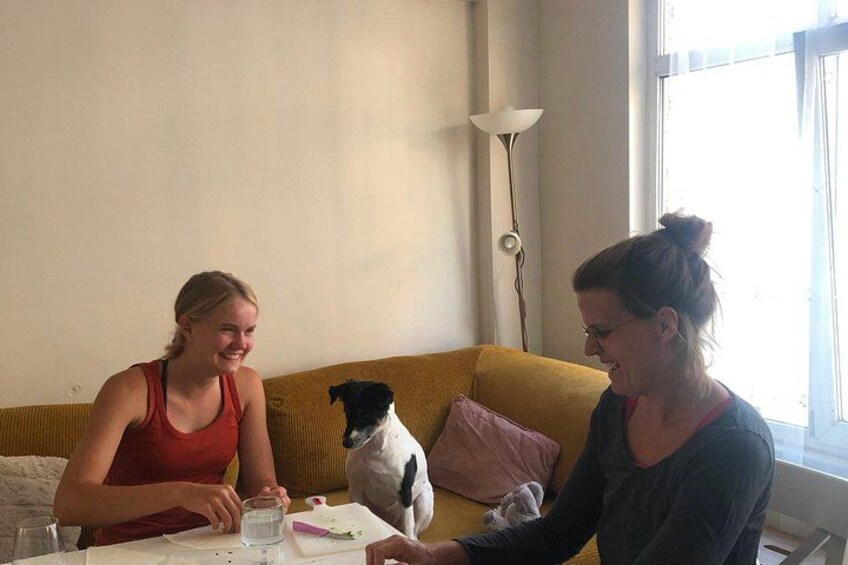 To personer sidder ved et bord, mens en hund ligger på en sofa. 4