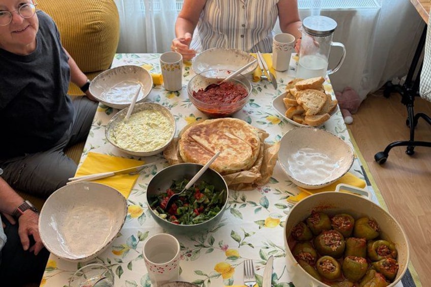 Een tafel met verschillende gerechten, waaronder een salade, gevulde paprika's en brood. 2