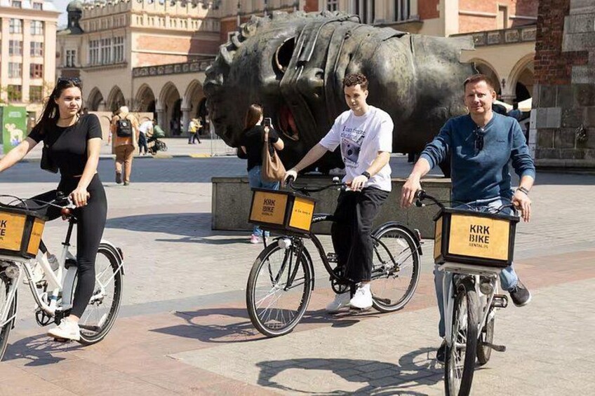 Drie personen fietsen, met 'KRY' tekens op de voorkant. 4
