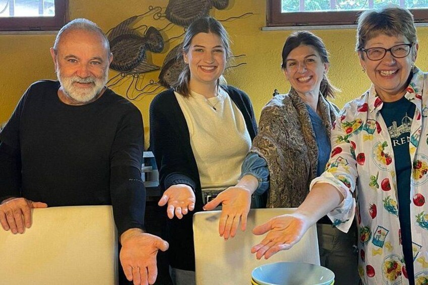 Four people standing in a room with a yellow wall and a painting. 5