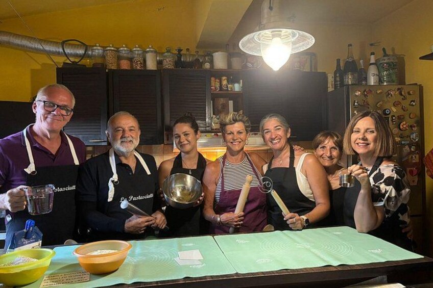 A group of people in a kitchen with cooking utensils and ingredients. 4