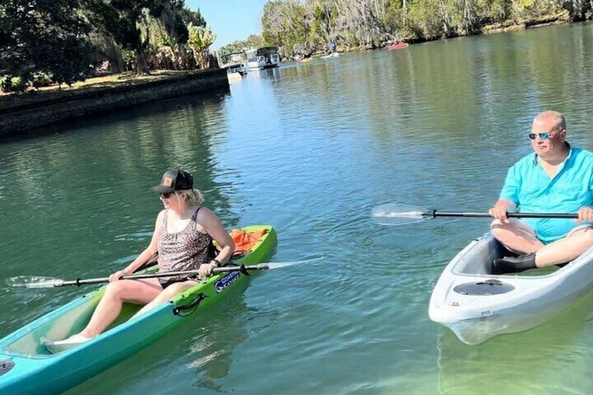 Two people kayaking on a calm river. 4