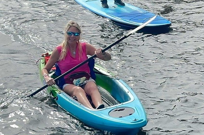 A person in a small blue kayak on a body of water. 2
