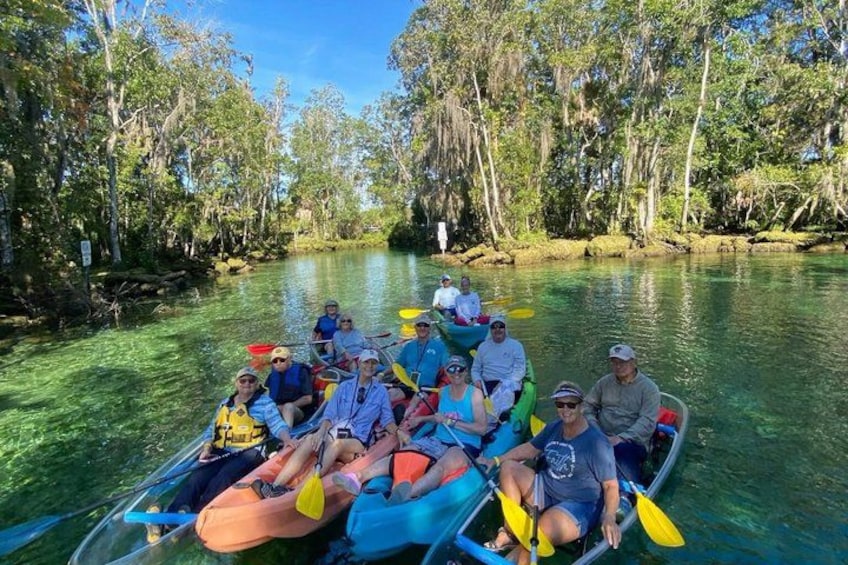 A group of people in a canoe on a river surrounded by trees. 5