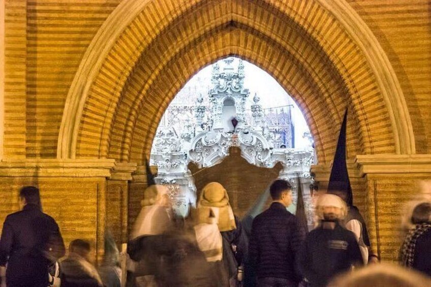 L’intérieur d’une cathédrale bondée, avec une grande porte en arc surmontée de sculptures complexes en pierre. 3
