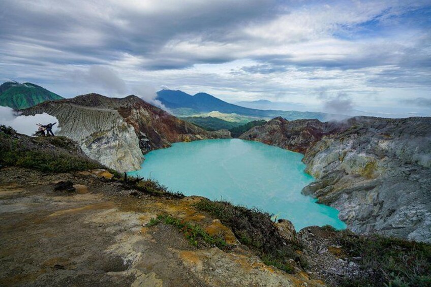 A large turquoise lake surrounded by rugged terrain and mountains. 5