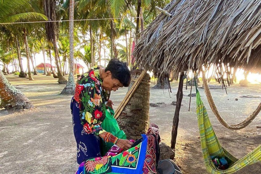 Una persona sentada en una hamaca bajo un techo de paja, rodeada de palmeras. 4