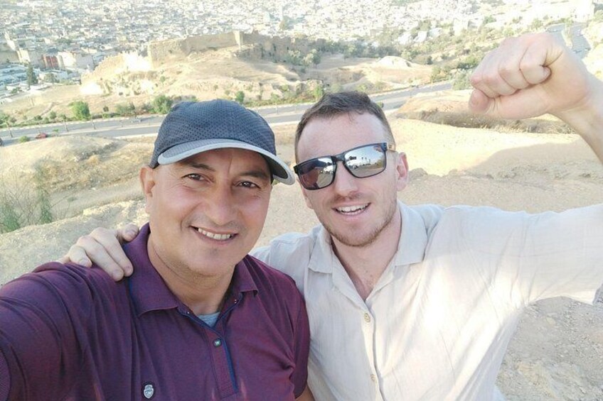 Two people taking a selfie with a historic cityscape in the background. 5