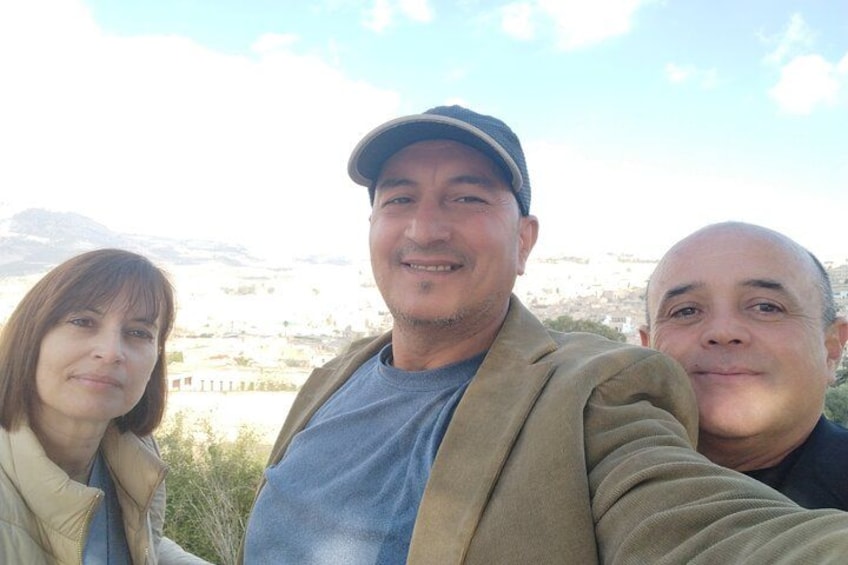 Three people taking a selfie with a mountainous landscape in the background. 2