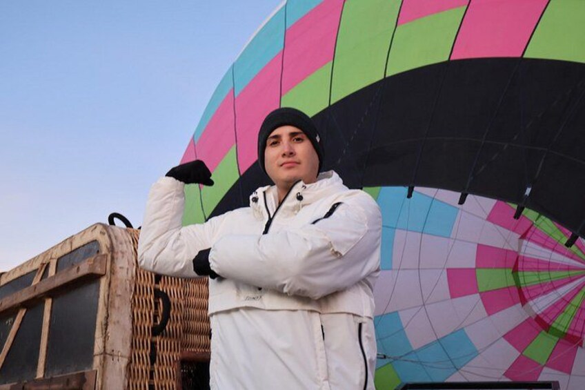 Een persoon staat voor een kleurrijke luchtballon. 2
