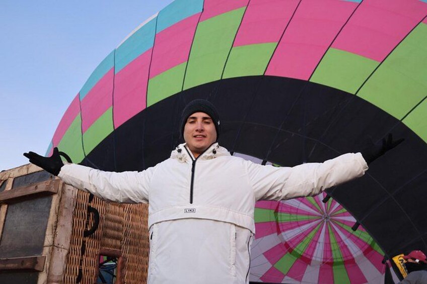 Een persoon staat voor een kleurrijke luchtballon. 4