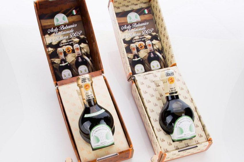 Two bottles of Aglio Balsamico in wooden boxes with labels. 1