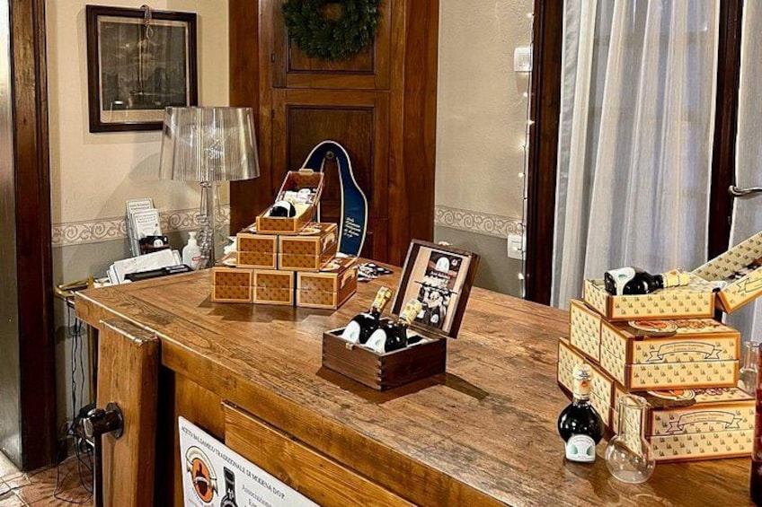 A wooden counter with various boxes and a guitar. 5